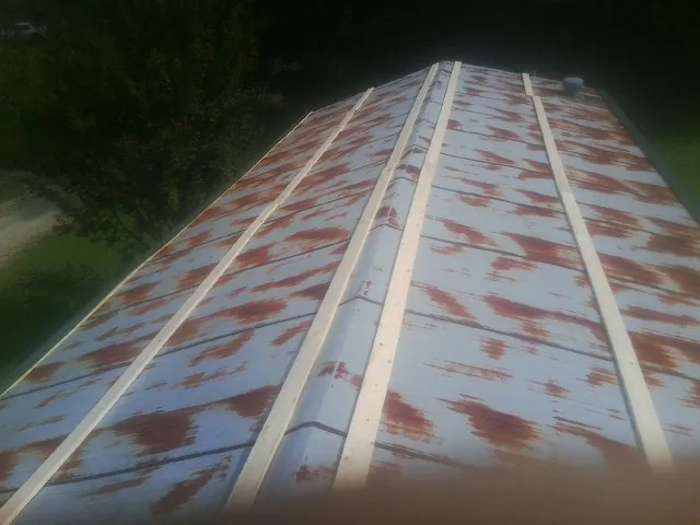 Rusted metal roof panels with new wood purlins before replacement — Storm Damage Roof Repair in Ford City by Roofing Brothers