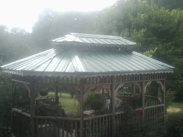 Two tier green metal roof on a garden gazebo in Ford City