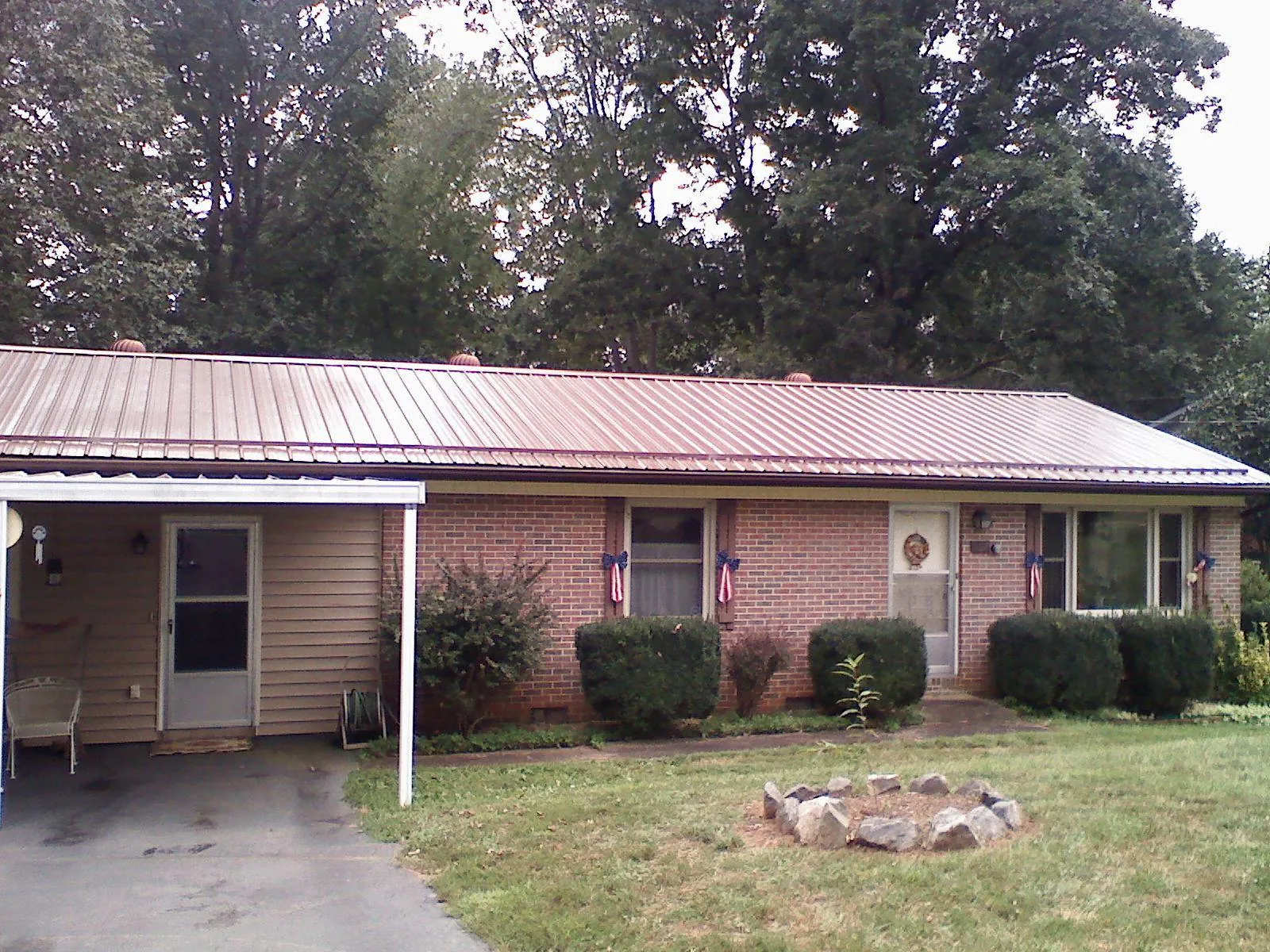 Bronze metal roof and carport on a brick ranch home — Roof Repair work by our crew in Ford City