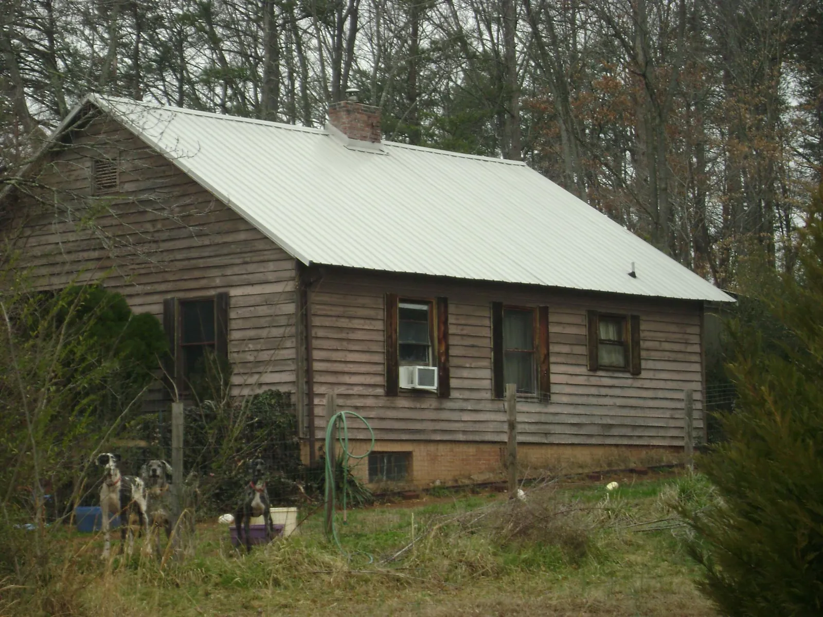 White metal roof on an old wood sided farmhouse, from a Metal Roof Installation job in Ford City